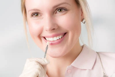 woman choosing her dental veneer color at CareSmiles Dental