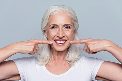 woman loving her restored smile thanks to CareSmiles Dental